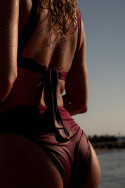 Femme portant une culotte de maillot de bain framboise uni et taille haute
