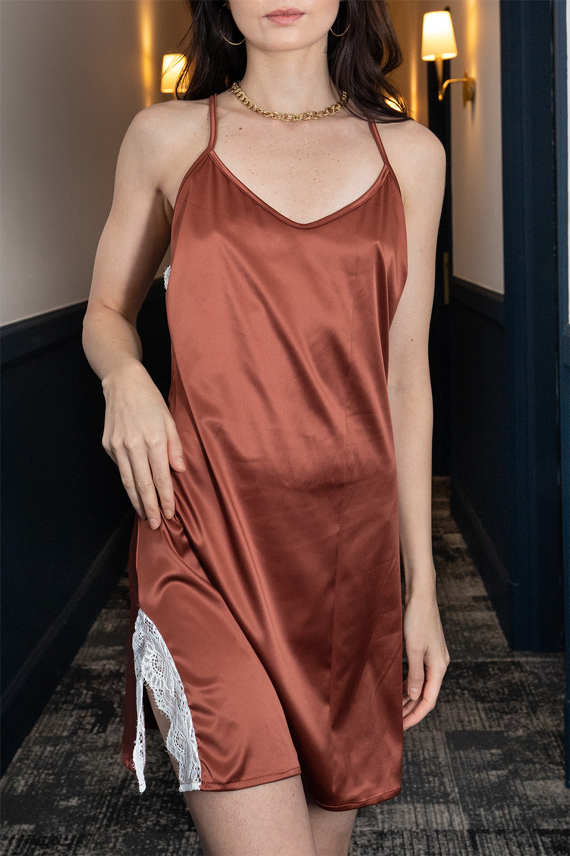 Femme portant une nuisette terracotta en satin à dos nu en dentelle blanche