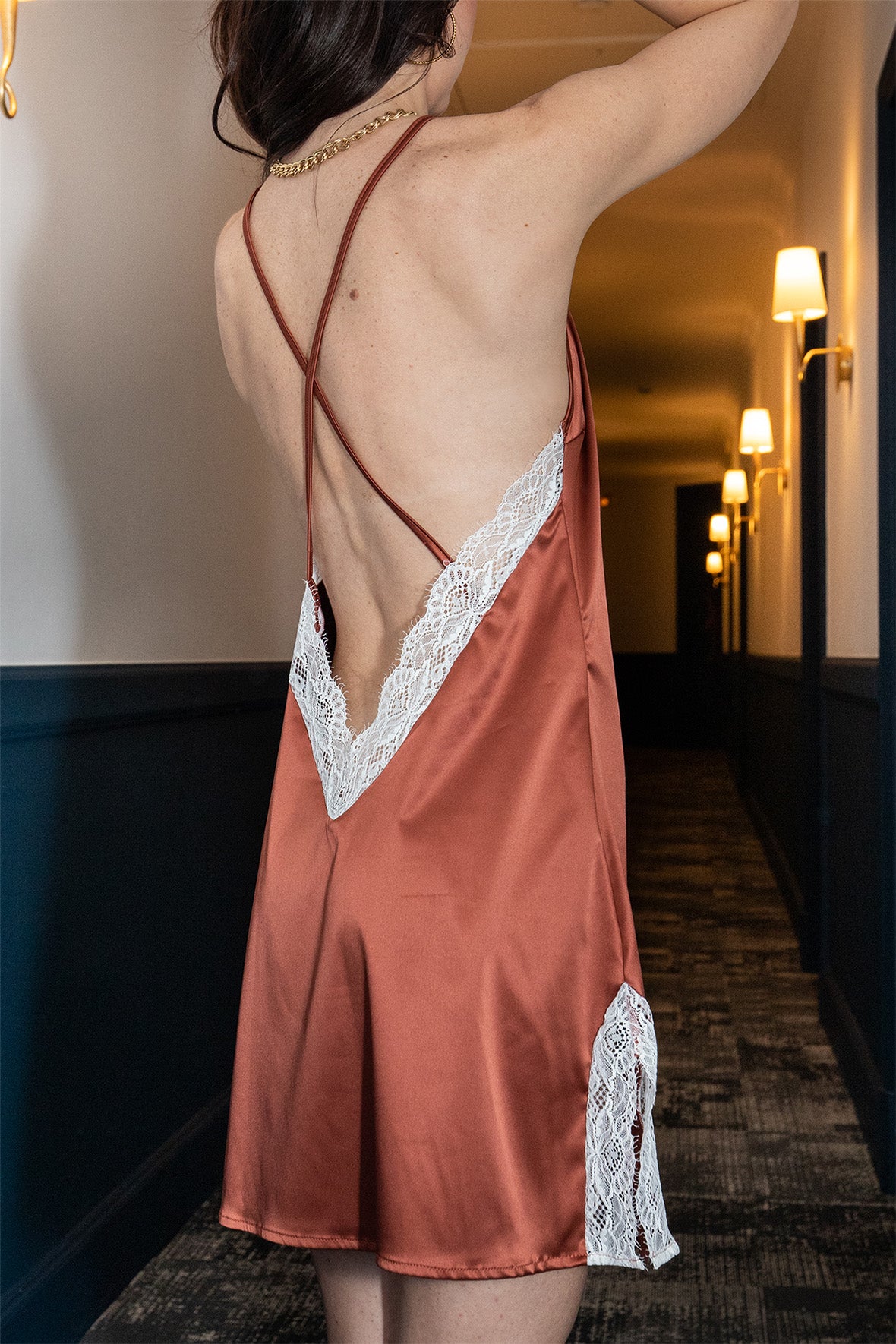 Femme portant une robe de nuit sexy et élégante de couleur rouge satiné et accompagné d'une dentelle blanche